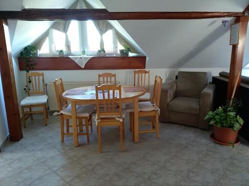 a dining room with a table and chairs and a couch at Koko Apartman in Tihany