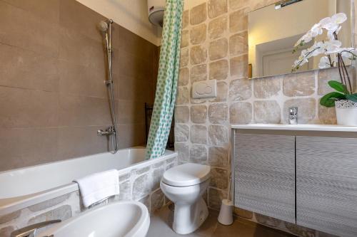 a bathroom with a toilet and a tub and a sink at Rome As You Feel - Santo Stefano in Rome