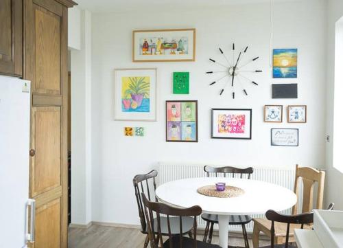 a kitchen with a table and chairs and a clock on the wall at Sogavegur 103 in Reykjavík