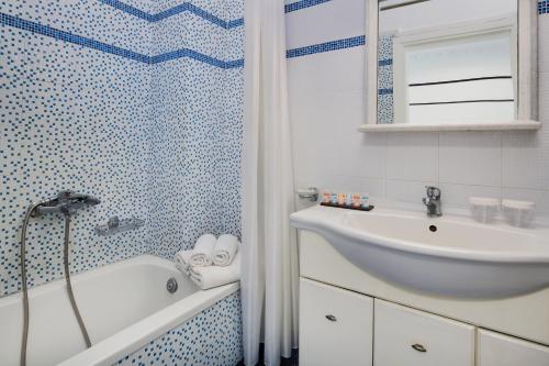 a bathroom with a tub and a sink and a shower at Villa Soula in Fira