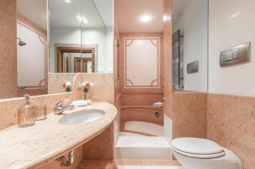 y baño con lavabo, aseo y espejo. en Ca' Dei Diamanti Grand Canal, en Venecia