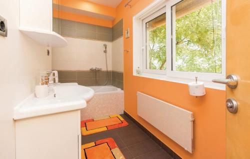 ein orangefarbenes Badezimmer mit einem Waschbecken und einer Badewanne in der Unterkunft Villa Vesna in Preko