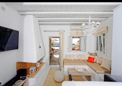 a living room with a couch and a table at Happy Villas Mykonos in Kalafatis
