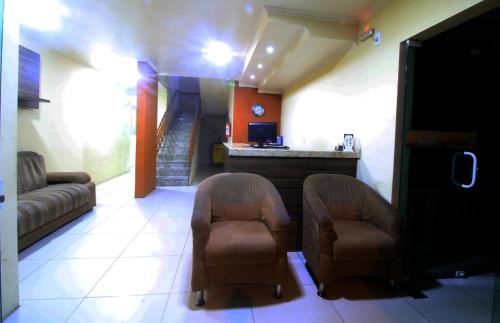 sala de estar con 2 sillas y sofá en Hotel Solare, en Santana do Livramento