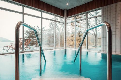 a swimming pool in a room with a large window at Destination Bokenäset in Uddevalla