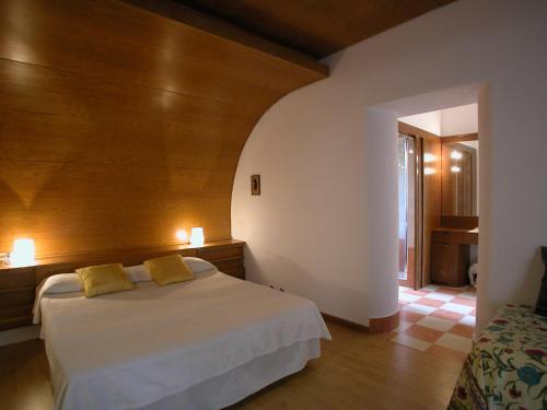 1 dormitorio con cama blanca y almohadas amarillas en Villa Teresa en Massa Marittima