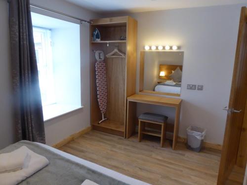 a room with a bedroom with a bed and a mirror at Auchendennan Farm Self Catering Cottages in Balloch