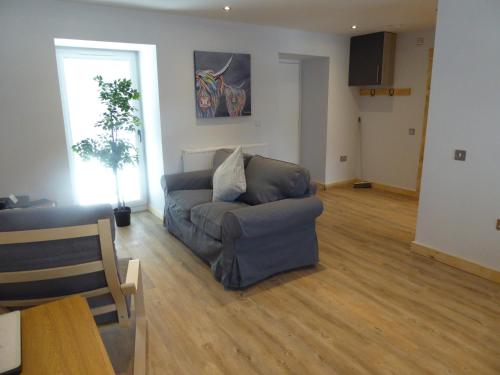 a living room with a couch and a table at Auchendennan Farm Self Catering Cottages in Balloch