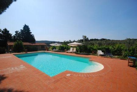 una gran piscina en un patio de ladrillo en Villa Teresa en Massa Marittima