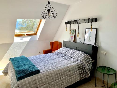 1 dormitorio con 1 cama, 1 silla y 1 ventana en Apartamento a 50 m de Playa-Jardín. Boiro, en Boiro
