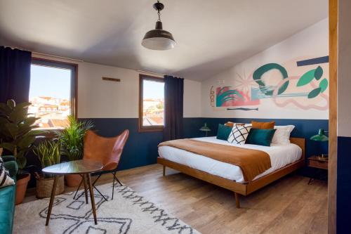 um quarto com uma cama, uma mesa e cadeiras em Selina Secret Garden Lisbon em Lisboa