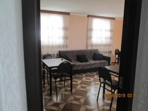 a living room with a couch and a table and chairs at Guesthouse Elli & Cottages in Stepantsminda