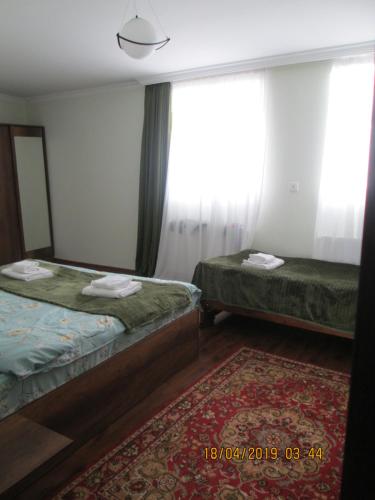 a hotel room with two beds and a mirror at Guesthouse Elli & Cottages in Stepantsminda