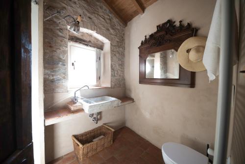 a bathroom with a sink and a window and a toilet at Casale Amati Country House in Ortonovo