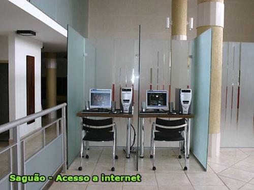 a room with a table with four computers on it at Apucarana Palace Hotel in Apucarana