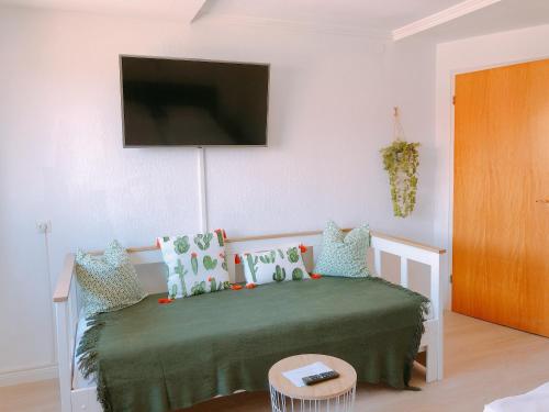 a bedroom with a bed with a television on the wall at Gästehaus Ehebachhof Hotel Garni in Müllheim