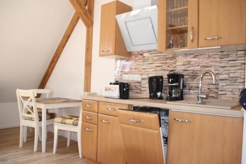 a kitchen with wooden cabinets and a counter top with a sink at Meine Fischerhütte in Börgerende-Rethwisch