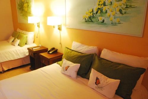 a hotel room with a bed with pillows at El Pueblito Iguazú in Puerto Iguazú