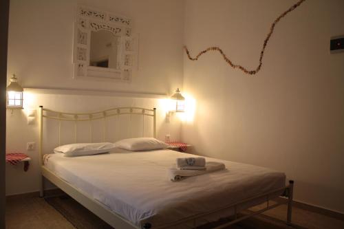 Un dormitorio con una cama blanca con una cometa en la pared en Olympias Studio "Pitsidia", en Pitsidia