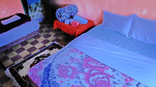 a bedroom with a bed and a red end table at Auberge des lacs in Imilchil