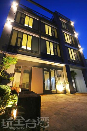 a large building with lit up windows at night at House16 in Green Island