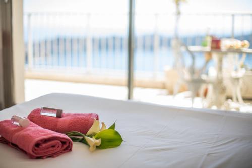 - une serviette rouge et une rose sur une table dans l'établissement LE CALIFORNIA - Villefranche-sur-Mer, à Villefranche-sur-Mer