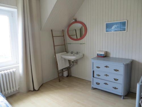 een badkamer met een wastafel en een spiegel bij MAISON KERLORZ in Bénodet