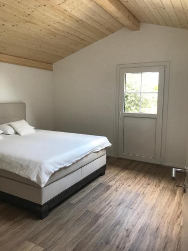a bedroom with a large bed and a window at Jade B&B in Bouveret