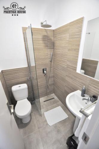 a bathroom with a shower and a toilet and a sink at Pensiunea Prestige House in Curtea de Argeş