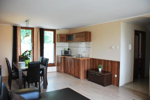 a kitchen with a table and a dining room at Albatrosz Apartman in Gyula