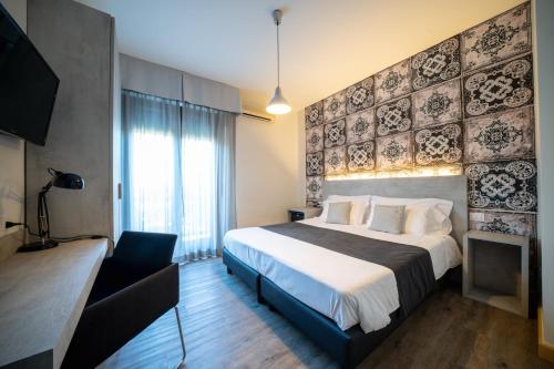 Habitación de hotel con cama grande y TV en B City Hotel, en Bardolino