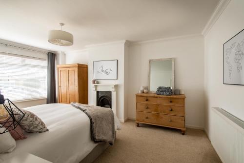 a bedroom with a bed and a mirror and a dresser at Beach Retreat in Whitstable