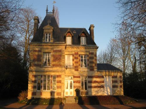 an old brick house with a gambrel roof at Château de Launay in Méry-Corbon