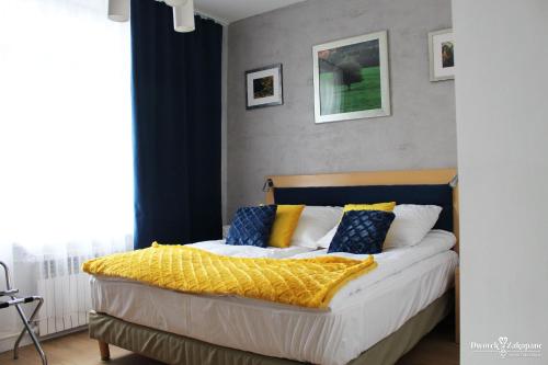 a bedroom with a bed with yellow and blue pillows at Dworek Zakopane in Zakopane