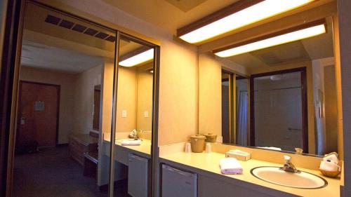 a bathroom with two sinks and two mirrors at El Rancho Boulder Motel in Boulder City