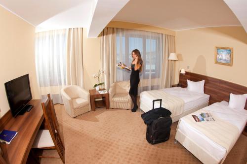 a woman is standing in a hotel room at Grand Hotel in Târgu-Mureş