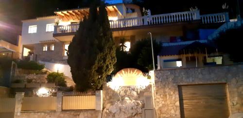 a large house at night with a garage at Ashram Villa Sunshine in Sitges