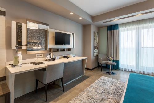 a hotel room with a desk and a tv at New Splendid Hotel & Spa - Adults Only (+16) in Mamaia