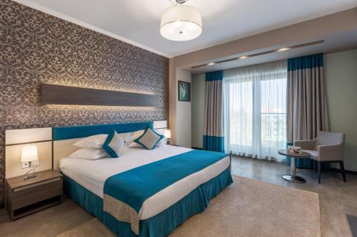 a hotel room with a large bed and a desk at New Splendid Hotel & Spa - Adults Only (+16) in Mamaia