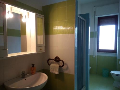uma casa de banho com um lavatório, um WC e um espelho. em Bed & Breakfast LA TERRAZZA em Latina