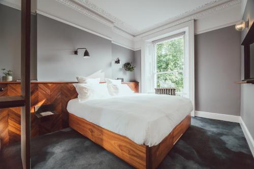 um quarto com uma cama grande e uma janela em The Pilgrm em Londres