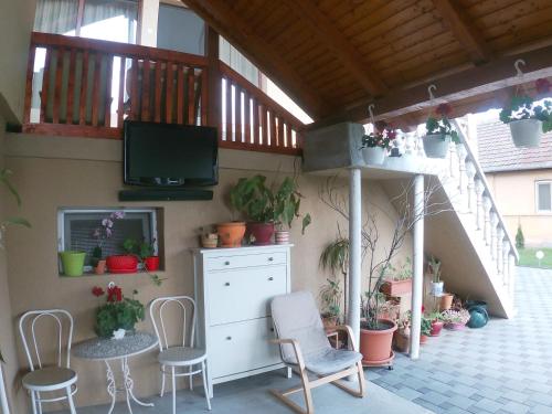 un patio con sillas y TV en un edificio en Casa Sannicolau en Sînnicolau Mare