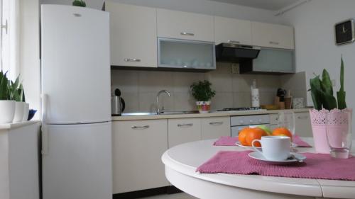 a kitchen with a white refrigerator and a table with fruit at Pineta25 in Pula