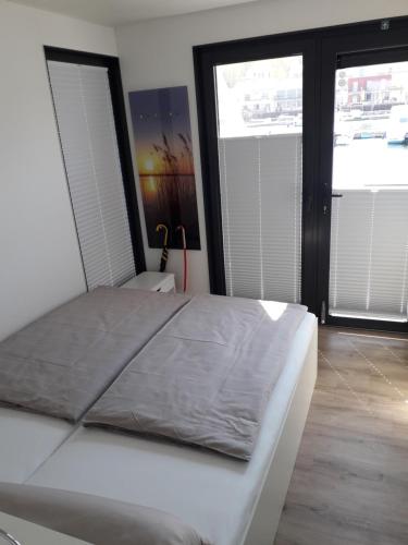 MüchelnにあるCalanthe - DAS HAUSBOOTの窓2つ付きの客室の白いベッド1台