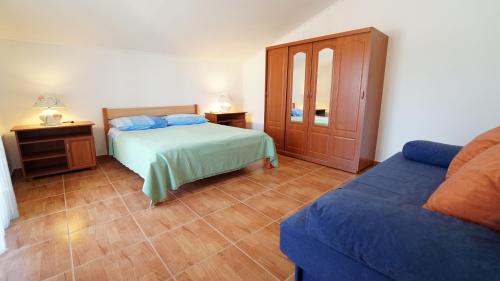 a bedroom with two beds and a couch in it at Apartments Roberta in Kožino
