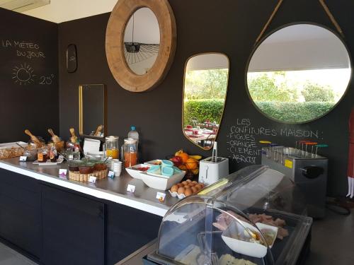 a counter with two round mirrors and a buffet with food at Poisson Rouge in Bonifacio