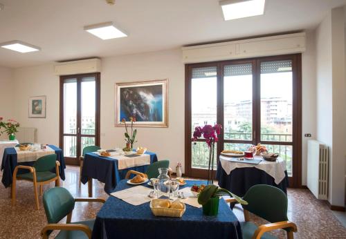 ein Restaurant mit blauen Tischen, Stühlen und Fenstern in der Unterkunft Casa Al Carmine in Padua