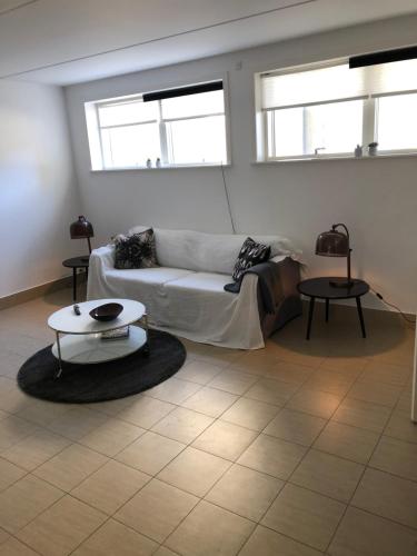 - un salon avec un canapé et deux tables dans l'établissement Cph Lux Apartment KV, à Copenhague