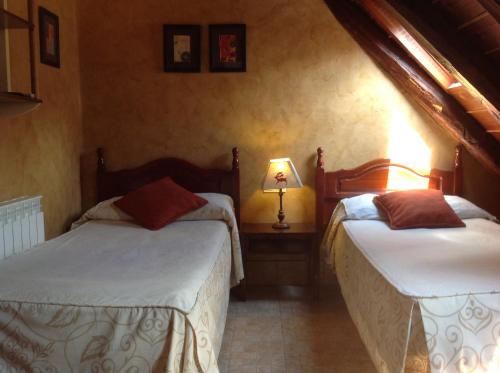 
a bedroom with two beds and two lamps at Pradets in Vielha
