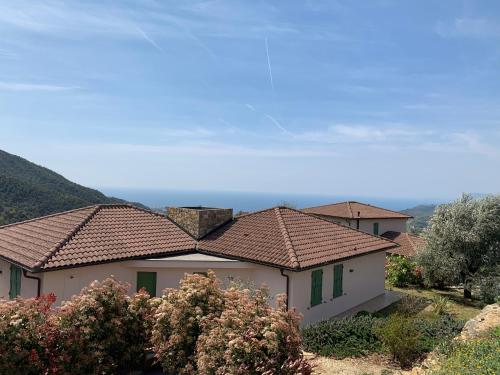a house with a tiled roof and some bushes at Antico Principato di Seborga in Vallebona